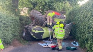 Tractor overturns on country lane in Gloucestershire